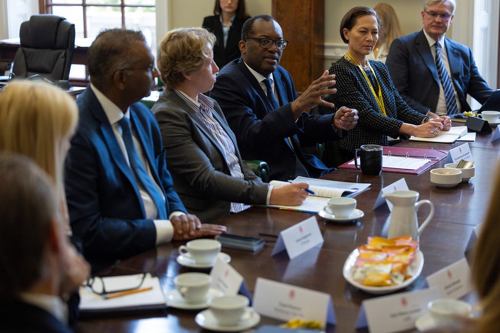 Kwasi Kwarteng sits at a table with representatives from investment banks