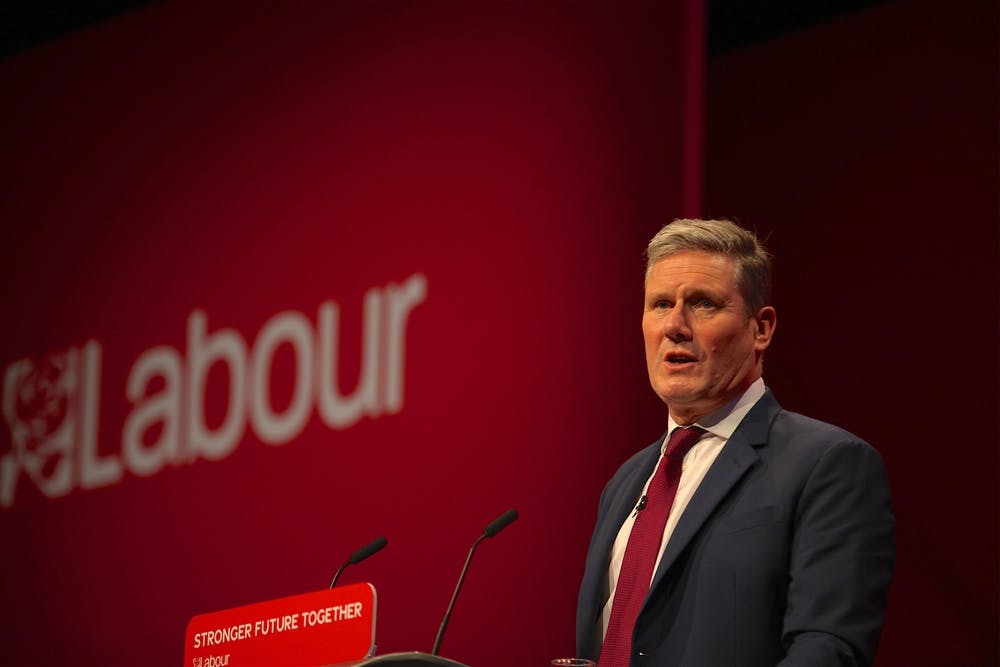 Keir Starmer stands at a podium in front of a Labour banner