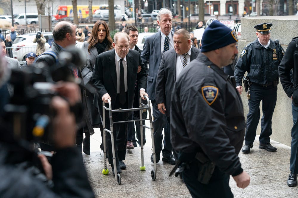 Harvey Weinstein arrives at a New York court, walking between security officers