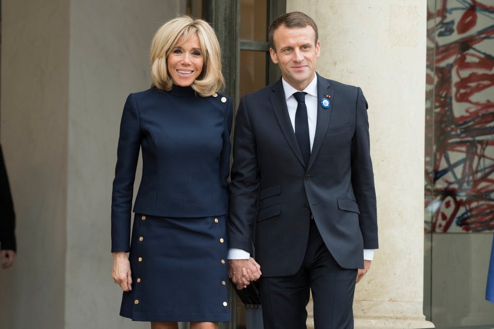 Brigitte and Emmanuel Macron walk hand in hand