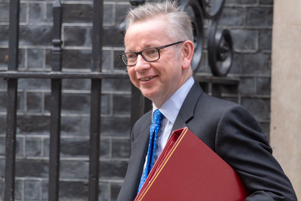 Michael Gove walks outside Downing Street carrying a red folder