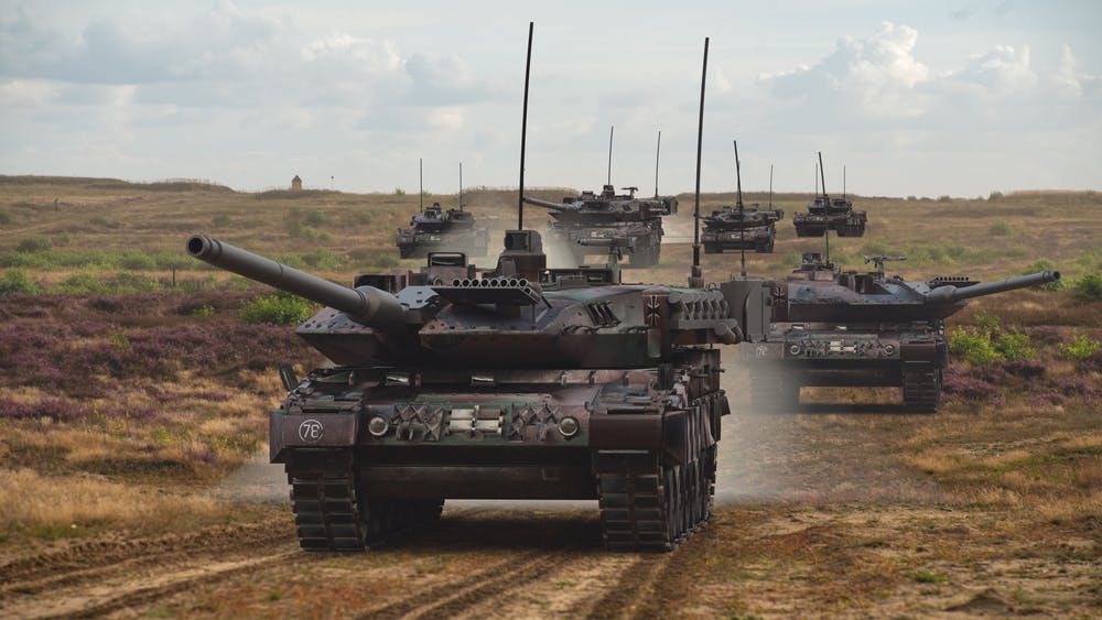 German Leopard tanks driving along a dirt road