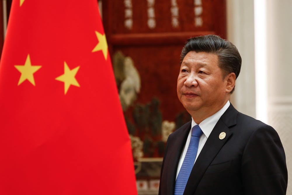 Xi Jinping next to Chinese flag