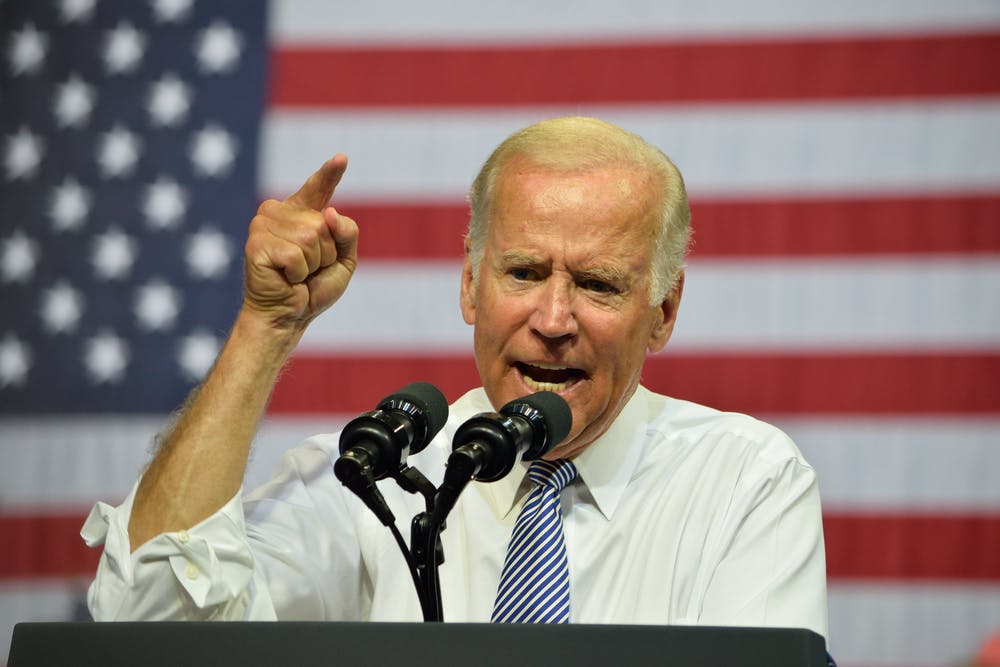 Joe Biden speaks at a podium in front of a US flag