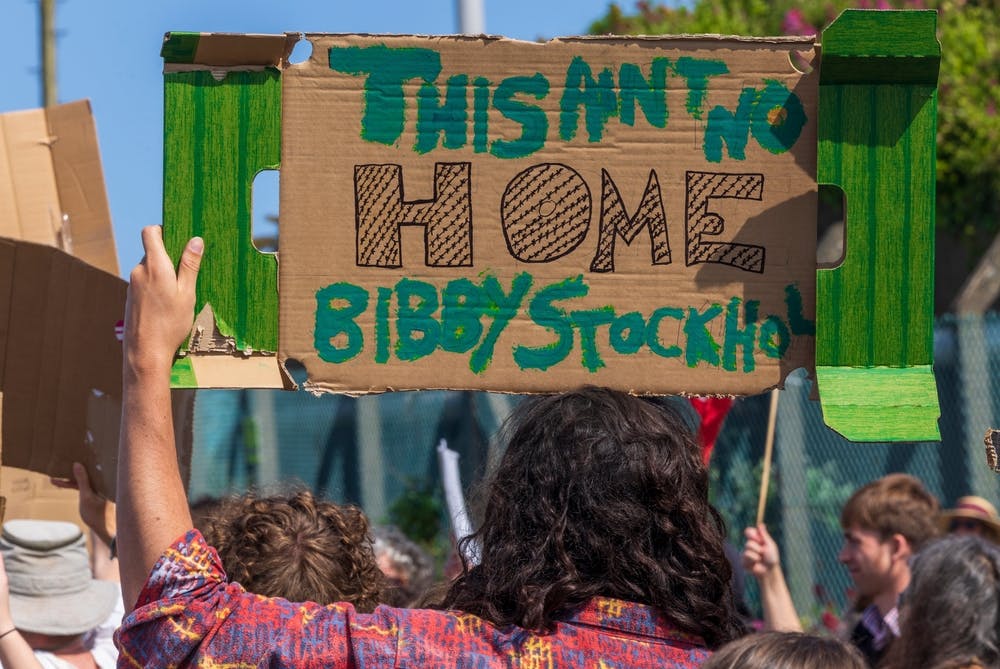 protester holds a sign reading This Ain't No Home Bibby Stockholm