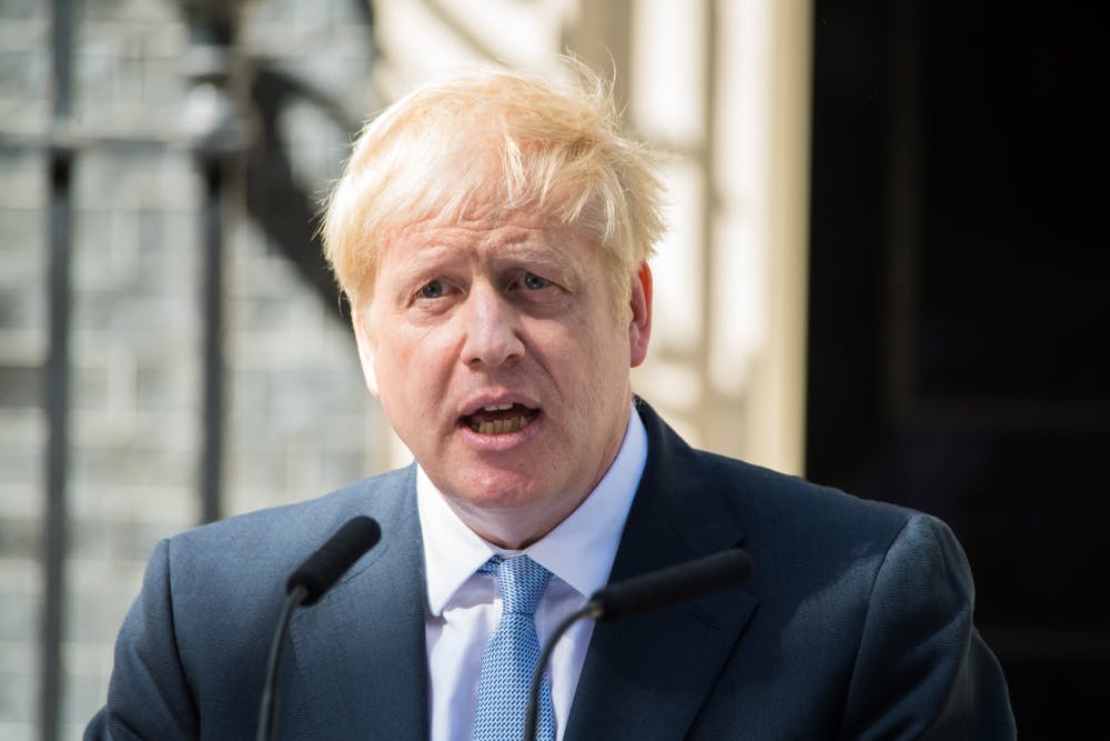 Boris Johnson stands at a microphone in front of Downing Street