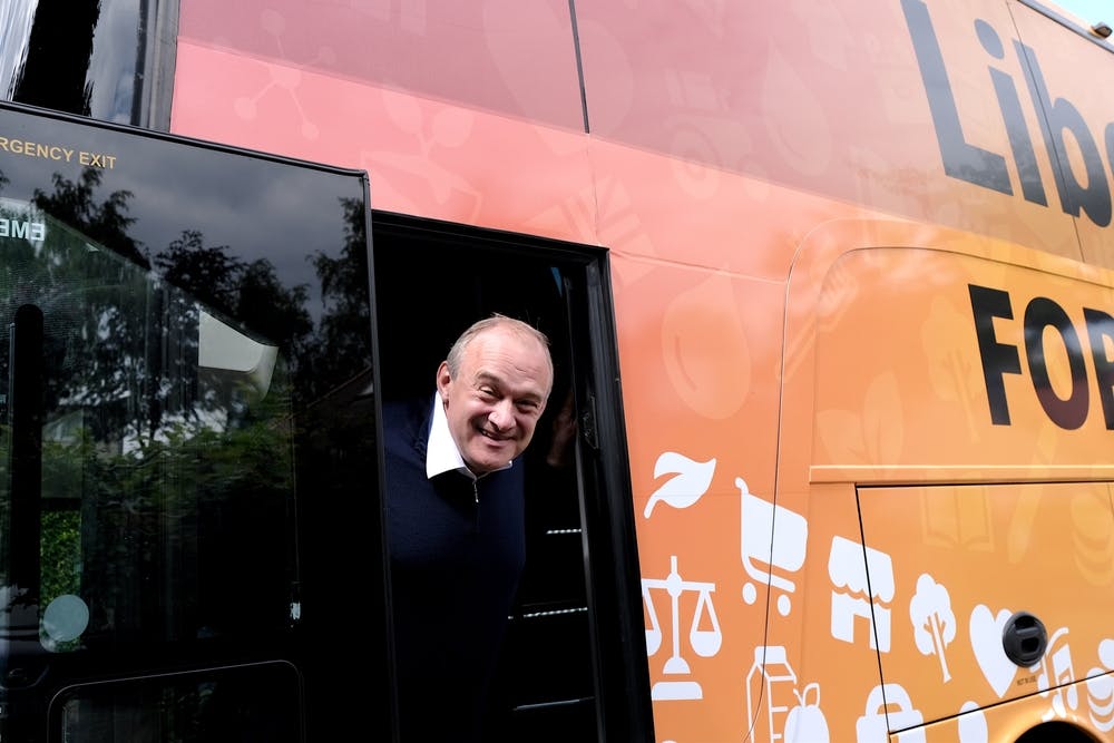 Ed Davey leans his head out of a bus door