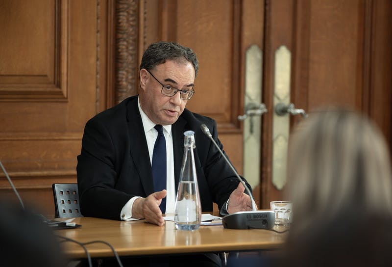 Andrew Bailey sits at a table and speaks into a microphone