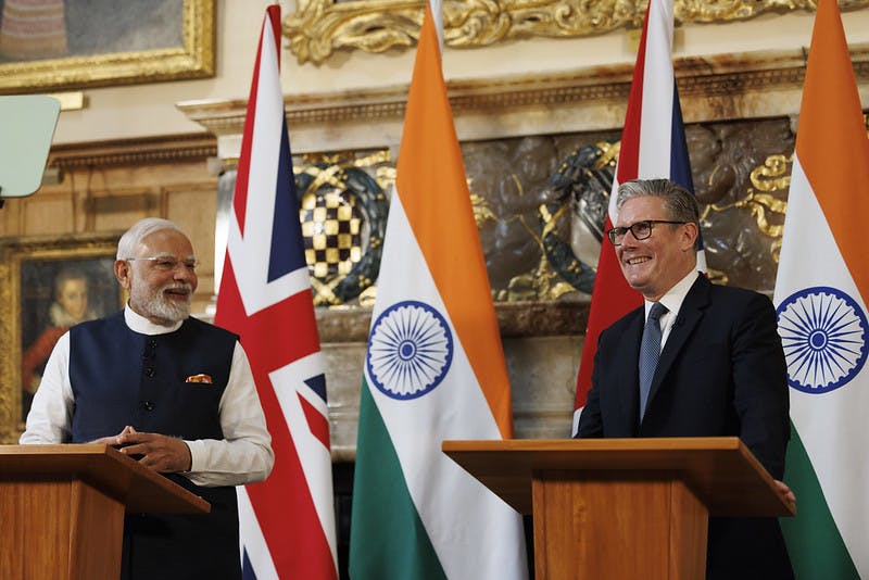 Narendra Modi and Keir Starmer stand at podiums in front of British and Indian flags at Chequers